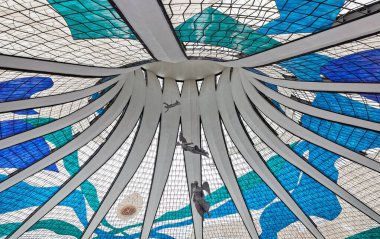 beautiful angel statues hanging from the ceiling with stained glass windows in Metropolitan Cathedral of Nossa Senhora Aparecida in Brasilia, Brazil