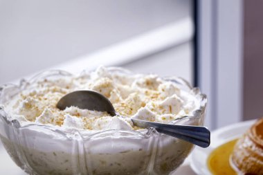 Beyaz arka planda cam tabakta kurabiye kırıntıları olan vanilyalı dondurma.