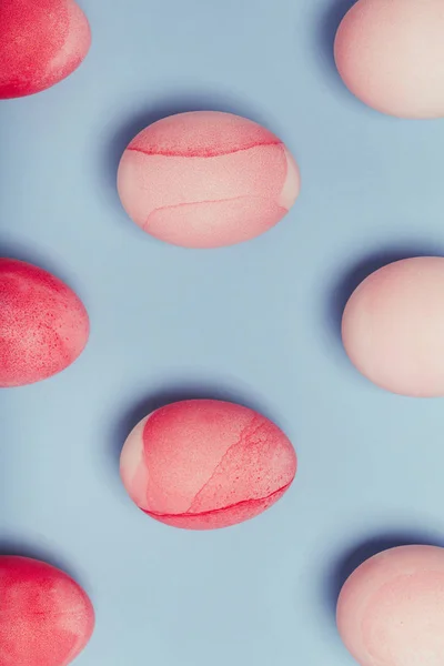 Patrón de huevos rosados sobre un fondo azul . — Foto de Stock