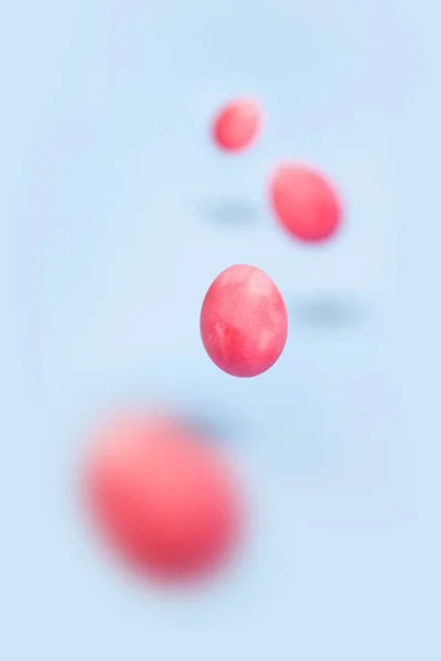 Fliegende rosa Hühnereier auf blauem Hintergrund — Stockfoto