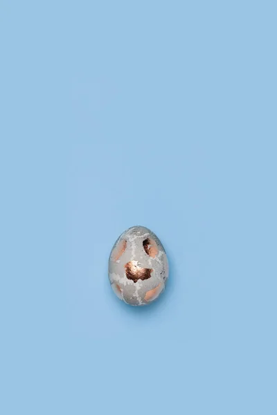 Een verguld chiken ei op een blauwe achtergrond — Stockfoto