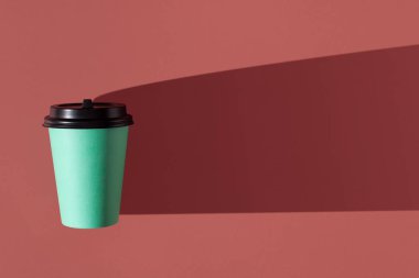 Pembe arka plan ve tek kağıt yeşil kupa. Trend sert gölgesi..