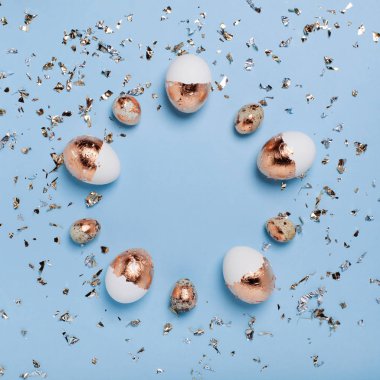 Beyaz altın yumurtalardan oluşan yuvarlak çerçeveli mavi arkaplan.