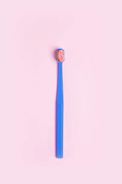 Cepillo de dientes brillante con pasta rosa de cerca sobre un fondo rosa — Foto de Stock