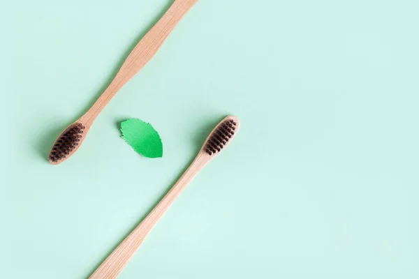 Fondo minimalista con dos cepillos de madera y una hoja de papel de menta — Foto de Stock