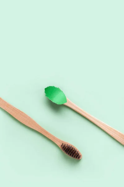 Fondo minimalista con dos cepillos de madera y una hoja de papel de menta — Foto de Stock