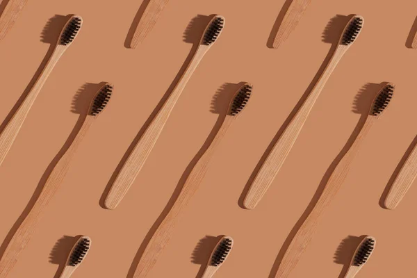 A row of wooden toothbrushes on a brown background — Stock Photo, Image