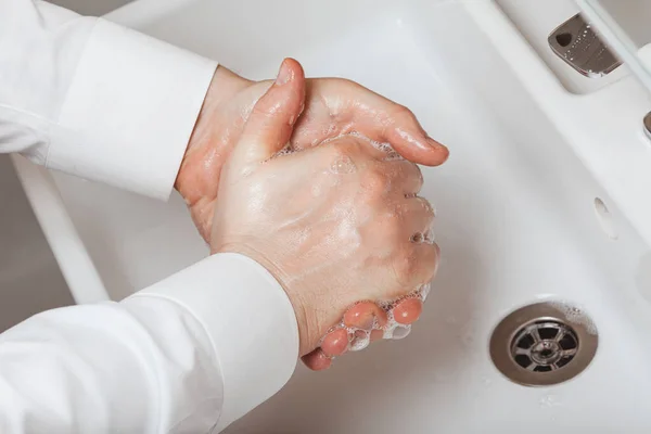 Facet dokładnie myje ręce w łazience. — Zdjęcie stockowe