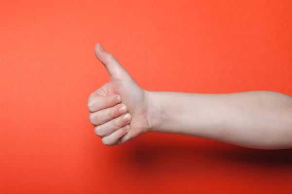 Gyerek kéz mutatja hüvelykujj fel a piros háttér — Stock Fotó