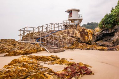 Cankurtaranlar gün doğumunda Hong Kong 'daki Big Wave Sahili' nin kayalıklarında ve kumlarında gözlem kulesi. 