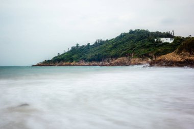 Gün doğumunda Hong Kong 'daki Big Wave Sahili' ndeki kayaların ve plajların deniz manzarası.
