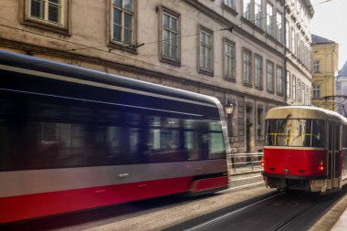 Prag 'daki modern ve eski tramvaylar güneşli bir günde hareket ediyor