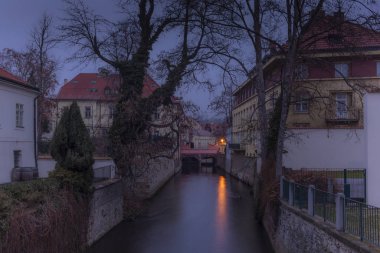 Prag 'da bir su kanalının kenarlarında bir köprü ve eski saraylar.