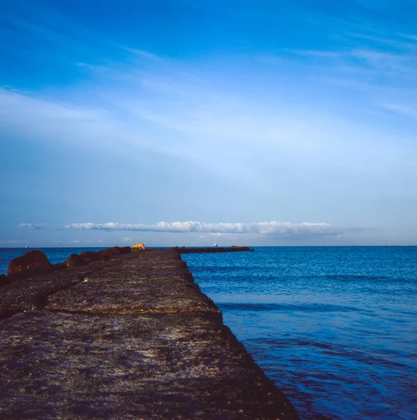 Um cais no Mar Mediterrâneo na Toscana ao pôr-do-sol com uma ilha — Fotografia de Stock