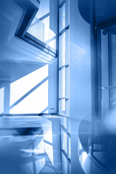 Ofis binası içinde, çok cam ve güneş var..