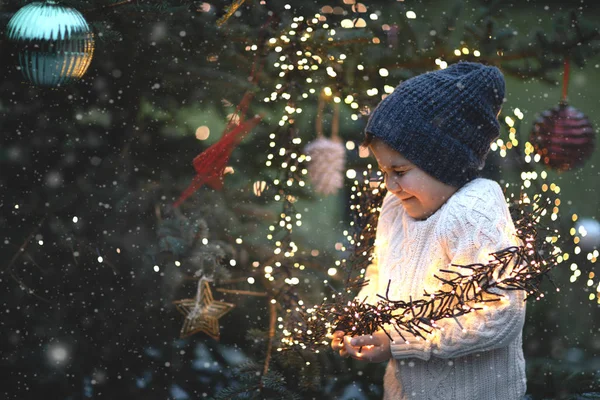 Erkek çocuk, Noel ağacı ve ampullerin olduğu klasik Noel arkaplanı..