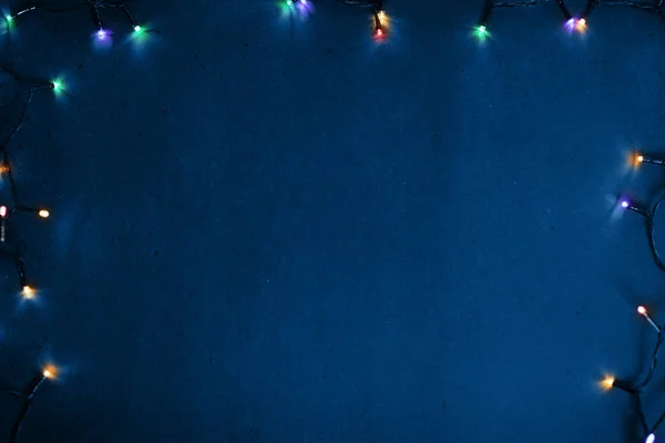 Mavi renkli bir duvarda yanan bir çelenk çerçevesi..