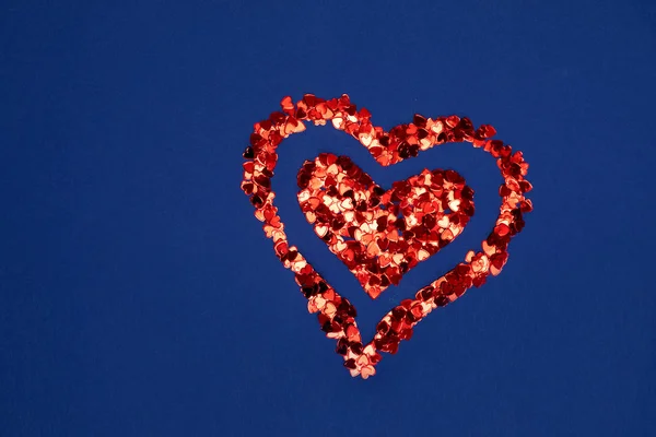 Mavi bir arka plan üzerinde kırmızı parlak kalp.