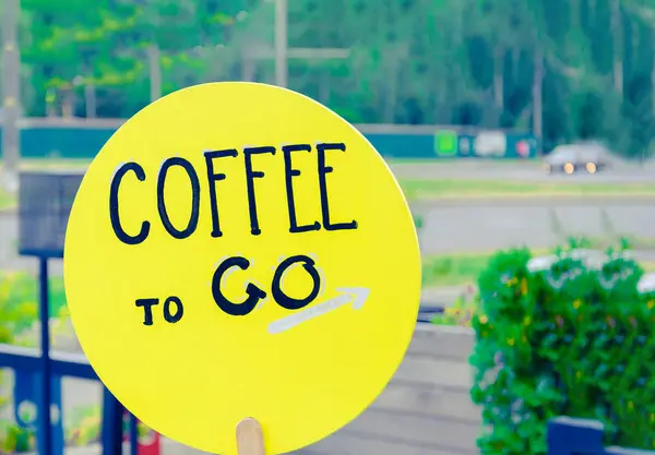 Επιγραφή καφέ για να πάει σε μια κίτρινη στρογγυλή πλάκα στο δρόμο. — Φωτογραφία Αρχείου