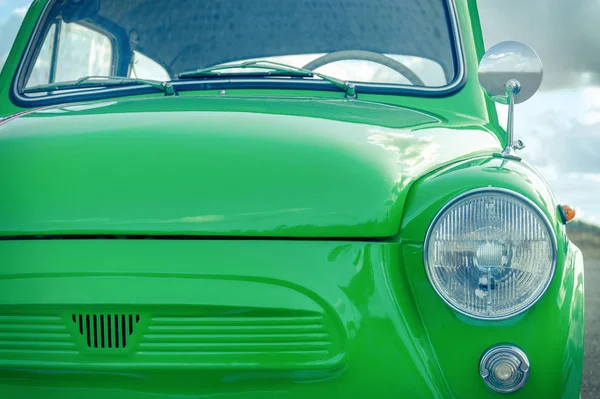 Pequeno carro retrô verde. conceito de carro retro. vista da frente do carro e do farol — Fotografia de Stock