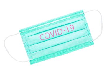 Beyaz arka planda yeşil tıbbi maske var. Maskedeki COVID-19 yazısı dünya koronavirüs salgınını sembolize ediyor.