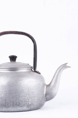 Beyaz arka plandaki eski model çaydanlık. Yakından izole edilmiş. Alüminyum malzemeden yapılmış bir çaydanlık..