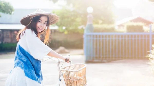 Retrato de uma bela mulher asiática com uma bicicleta — Fotografia de Stock