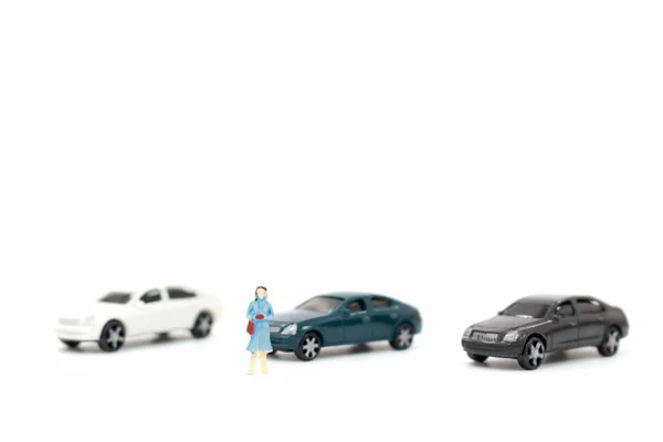 Miniaturní figurky žen a auto na bílém pozadí — Stock fotografie