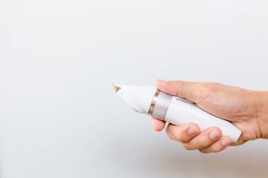 Saç kesme makineleri gri arka plan üzerinde tutan el 