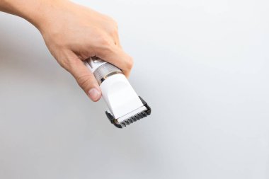 Saç kesme makineleri gri arka plan üzerinde tutan el 