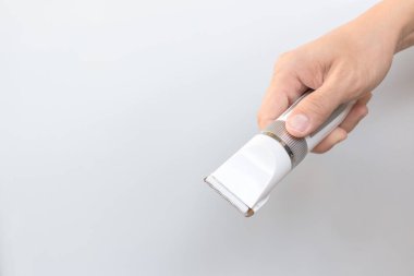 Saç kesme makineleri gri arka plan üzerinde tutan el 