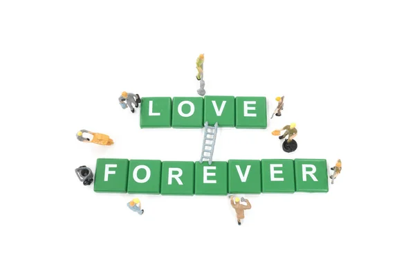 Miniatura trabajador equipo construcción palabra amor para siempre en blanco backgr —  Fotos de Stock