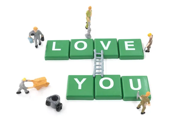 Miniatuur werknemer teambuilding woord love u op witte achtergrond — Stockfoto