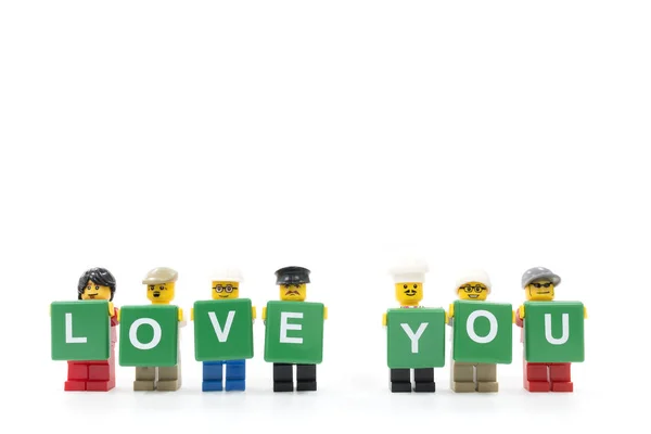 Studio shot de LEGO minifigure sosteniendo la palabra LOVE YOU sobre fondo blanco —  Fotos de Stock