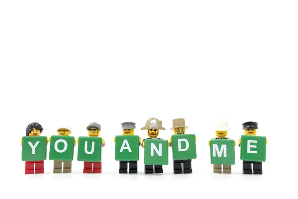 Студийный кадр LEGO minifigure держа слово вы и я на белом фоне — стоковое фото