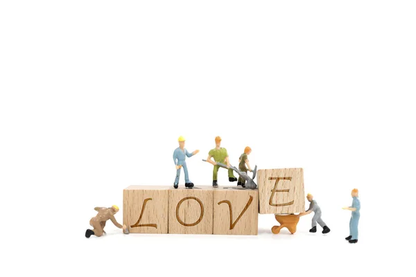 Miniatura lavoratore squadra costruzione parola amore su sfondo bianco — Foto Stock