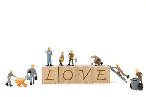 微型工人团队建设爱字，在白色背景上 — 图库照片