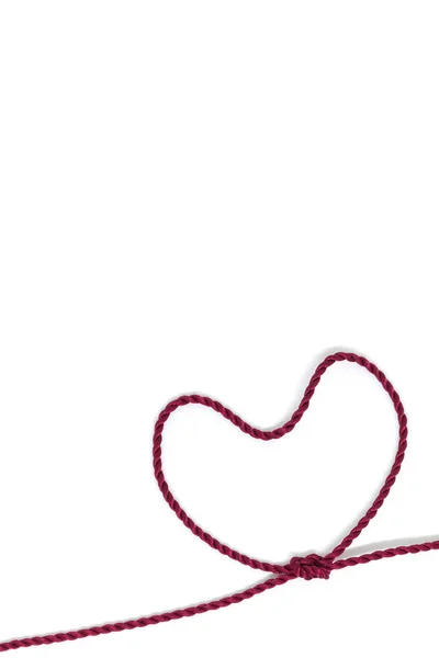 Herzförmiger Knoten auf einem Seil auf weißem Hintergrund — Stockfoto