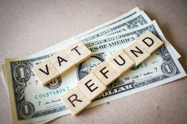 Wooden block word VAT REFUND and Dollar banknote — Stock Photo, Image