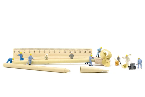 Miniatyr arbetare team vässa en blyertspenna — Stockfoto