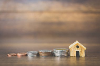 Sikke para ve ev ahşap arka plan üzerinde model 