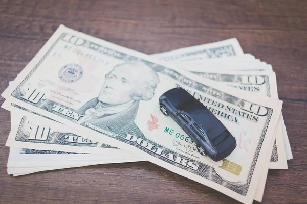Bilmodell på dollar sedlar på trä bakgrund — Stockfoto