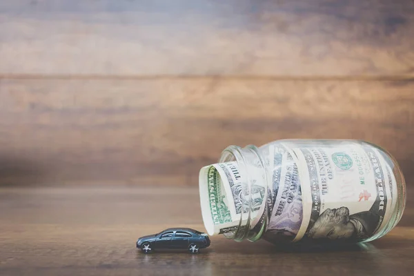 Car model on dollar banknotes  on wooden background — Stock Photo, Image