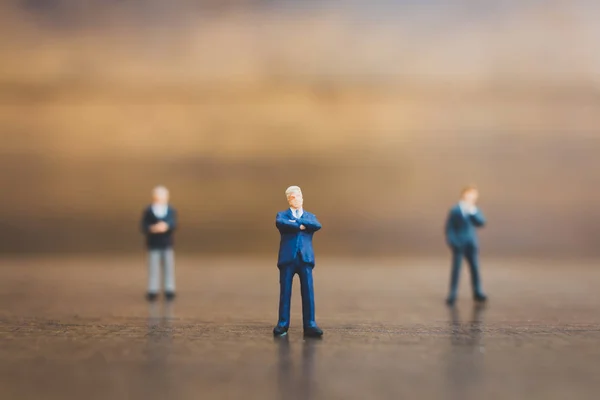 Personas en miniatura hombre de negocios sobre fondo de madera — Foto de Stock