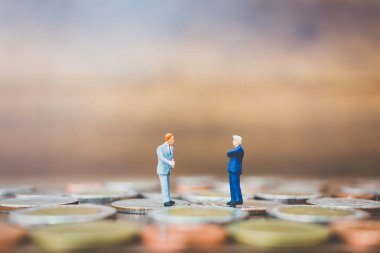 Minyatür insanlar işadamı para üzerinde duran