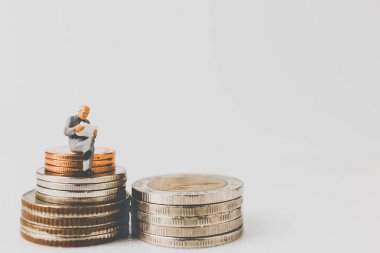 Bir boşluk ile sikkeler üzerinde oturan minyatür insanlar iş kavramı 