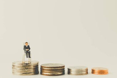 Bir boşluk ile sikkeler üzerinde oturan minyatür insanlar iş kavramı 