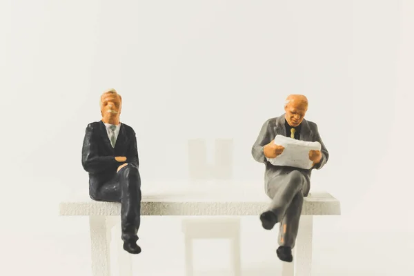 Miniaturní lidé obchodního konceptu sedí na židli s mezerou — Stock fotografie