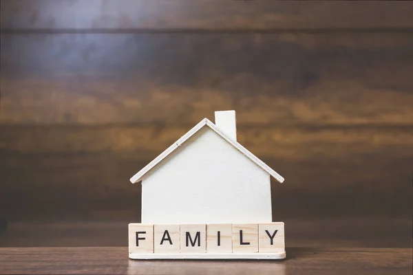Hausmodell mit Familienwort auf Holzklötzen. — Stockfoto