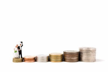Minyatür insanlar üzerinde düğün beyaz arka plan üzerinde sikke yığını.